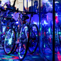 bikes decorated with lights leaning against a glass wall