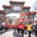 a cultural parade marching through the gates to Chinatown