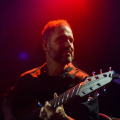 man with a beard playing a guitar