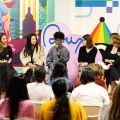 a panel of people on stage speaking to a listening audience