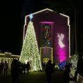 a stone building and a tree lit with many lights for Christmas 