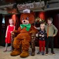 kids pose for photos with a giant teddy bear