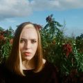 a woman in front of green plants