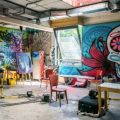 an art studio with paintings being created and art on the walls