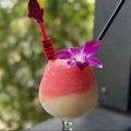 a slushy frozen drink with a flower garnish