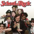 a man poses with kids in rock and roll outfits