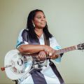 woman sitting with a silver guitar