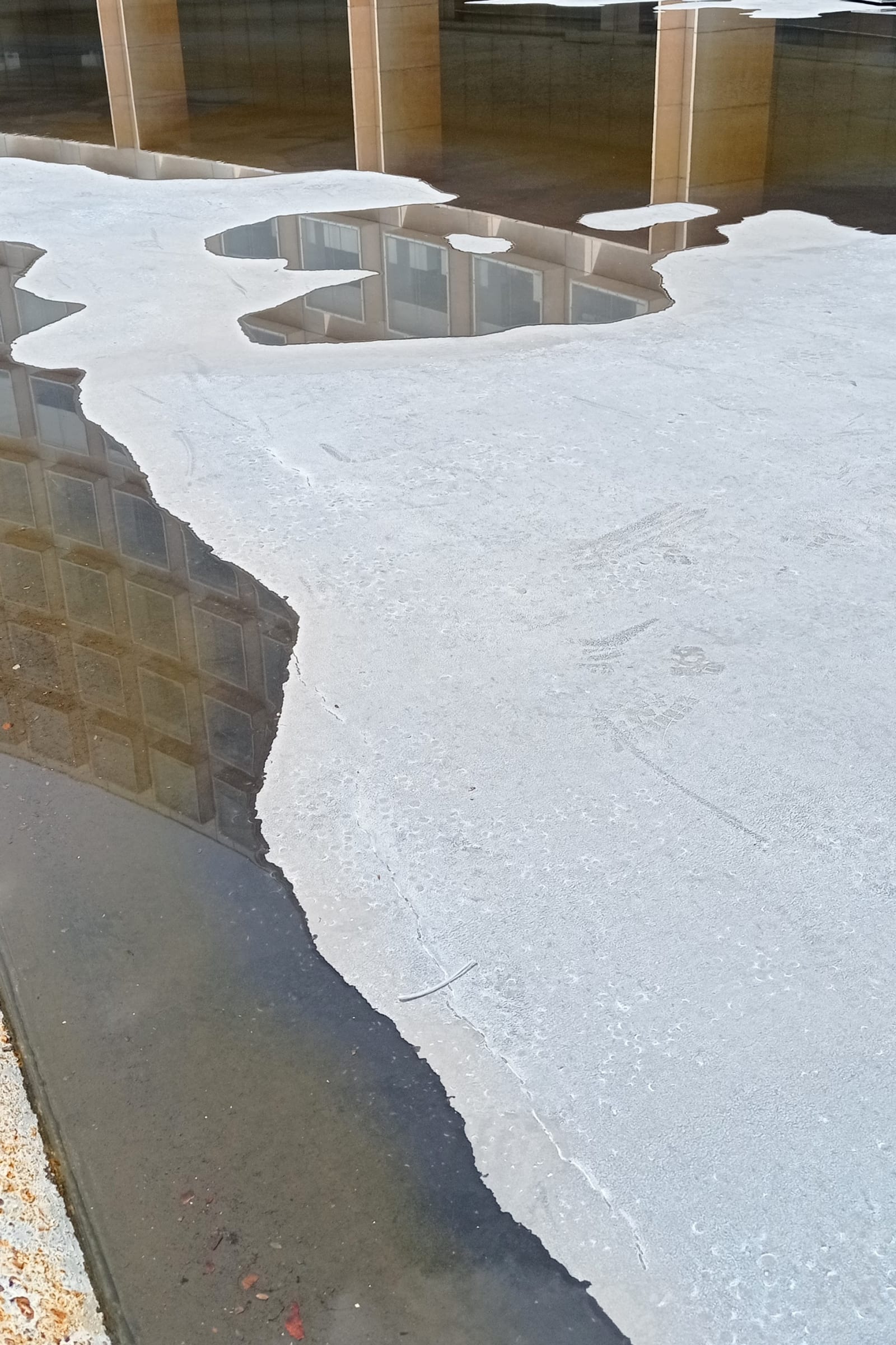 common ground - a thin layer of water is poured on the ground to reflect the building upside down - floor, water, building - paul lahana