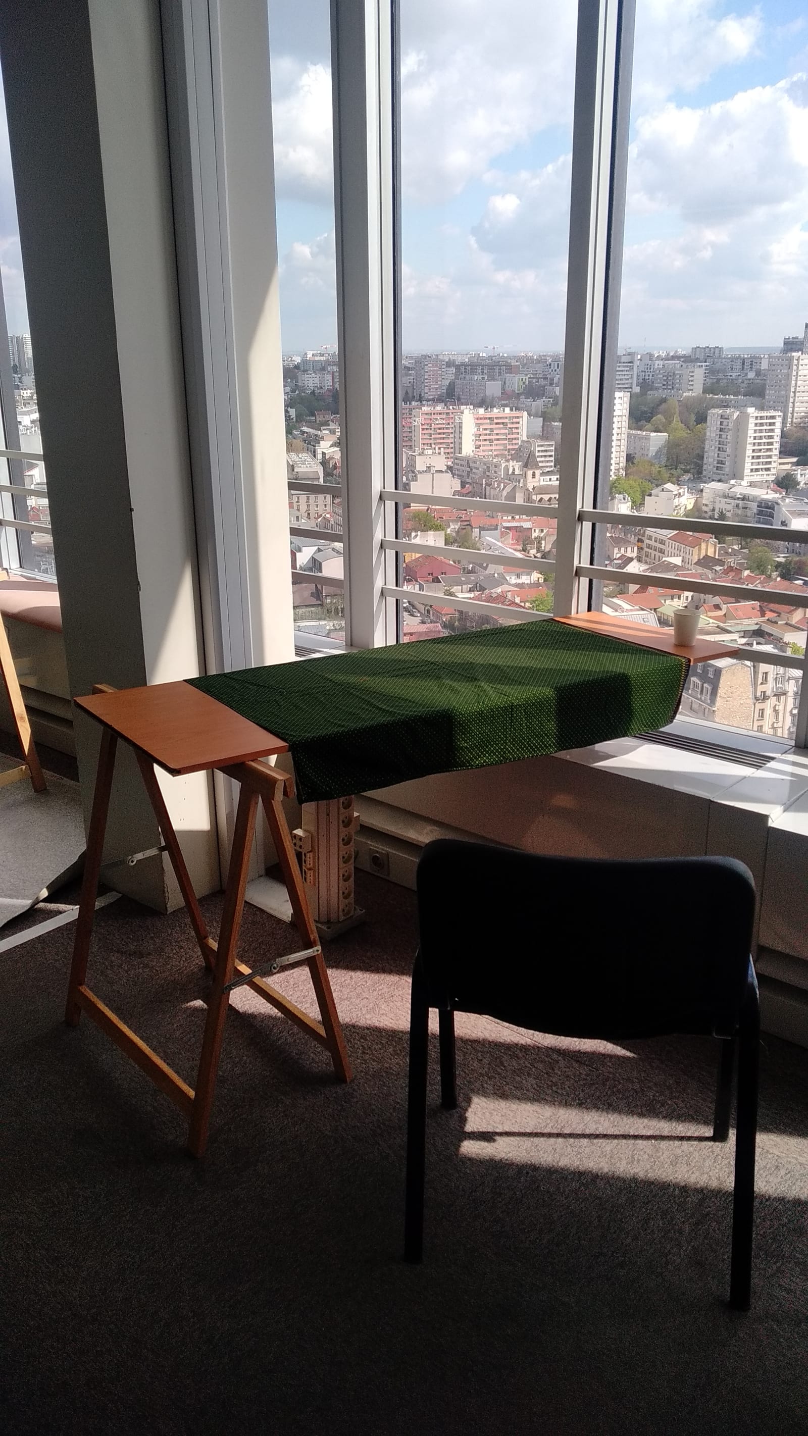 office building - A wood board holds itself horizontally thanks to a trestle that is the same height as the safety post on the window - wood board, trestle, safety post - paul lahana