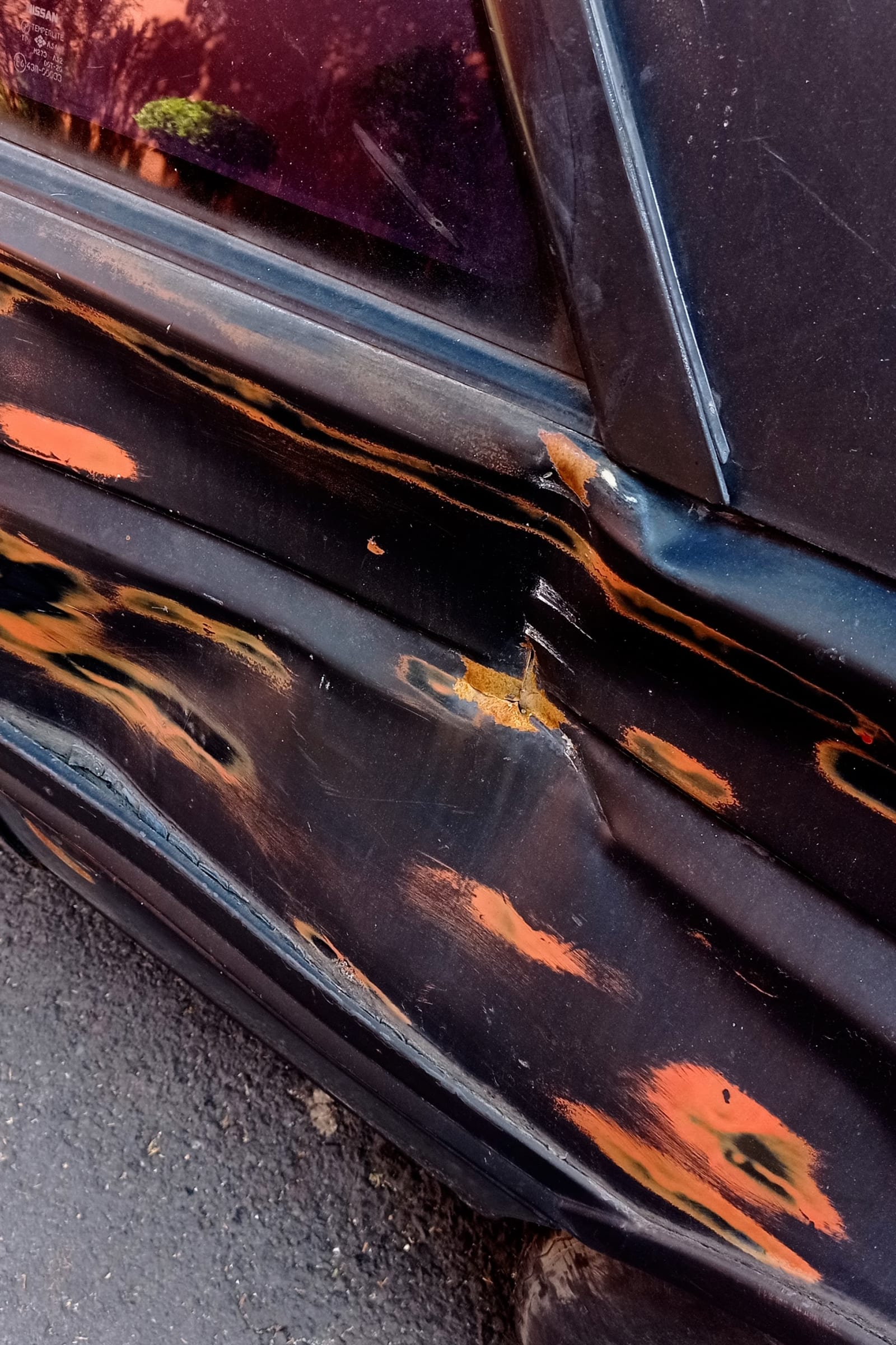 broke - on a car, the orange paint appears as the black paint gets sanded and, somehow, some black paint appears under the orange - car, orange paint, two (2) layers of black paint - paul lahana