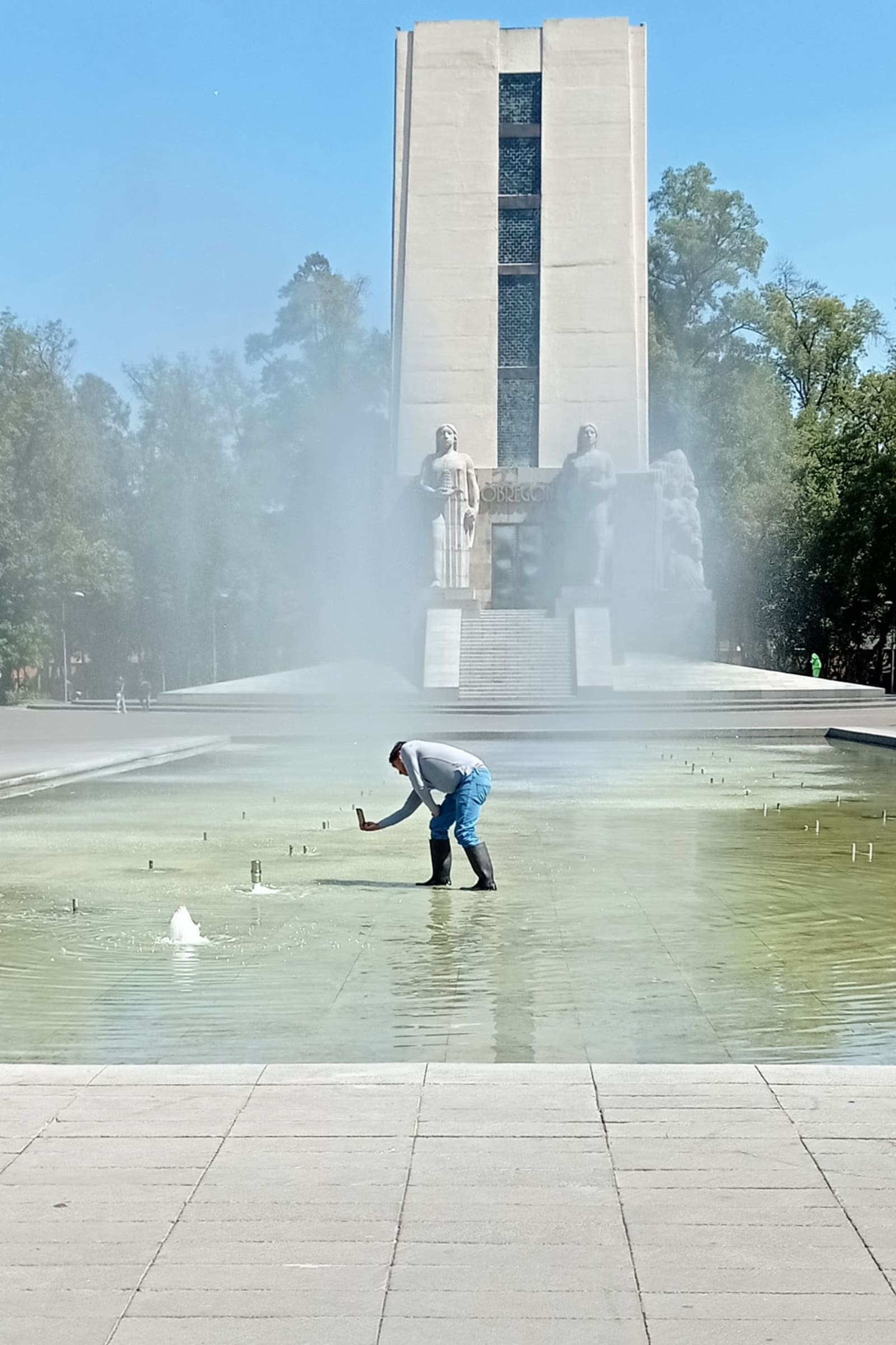 self-portrait (but with this dude instead of me) - artist standing in the fountain trying his best to take a good picture of the water - fountain, water, dude, smartphone - paul lahana