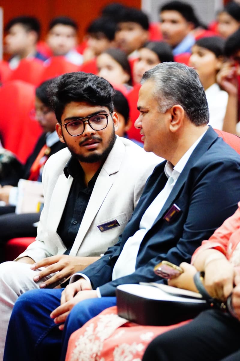 Delegates and guests seated in red auditorium chairs during the Delhi MUN 1.0 opening ceremony