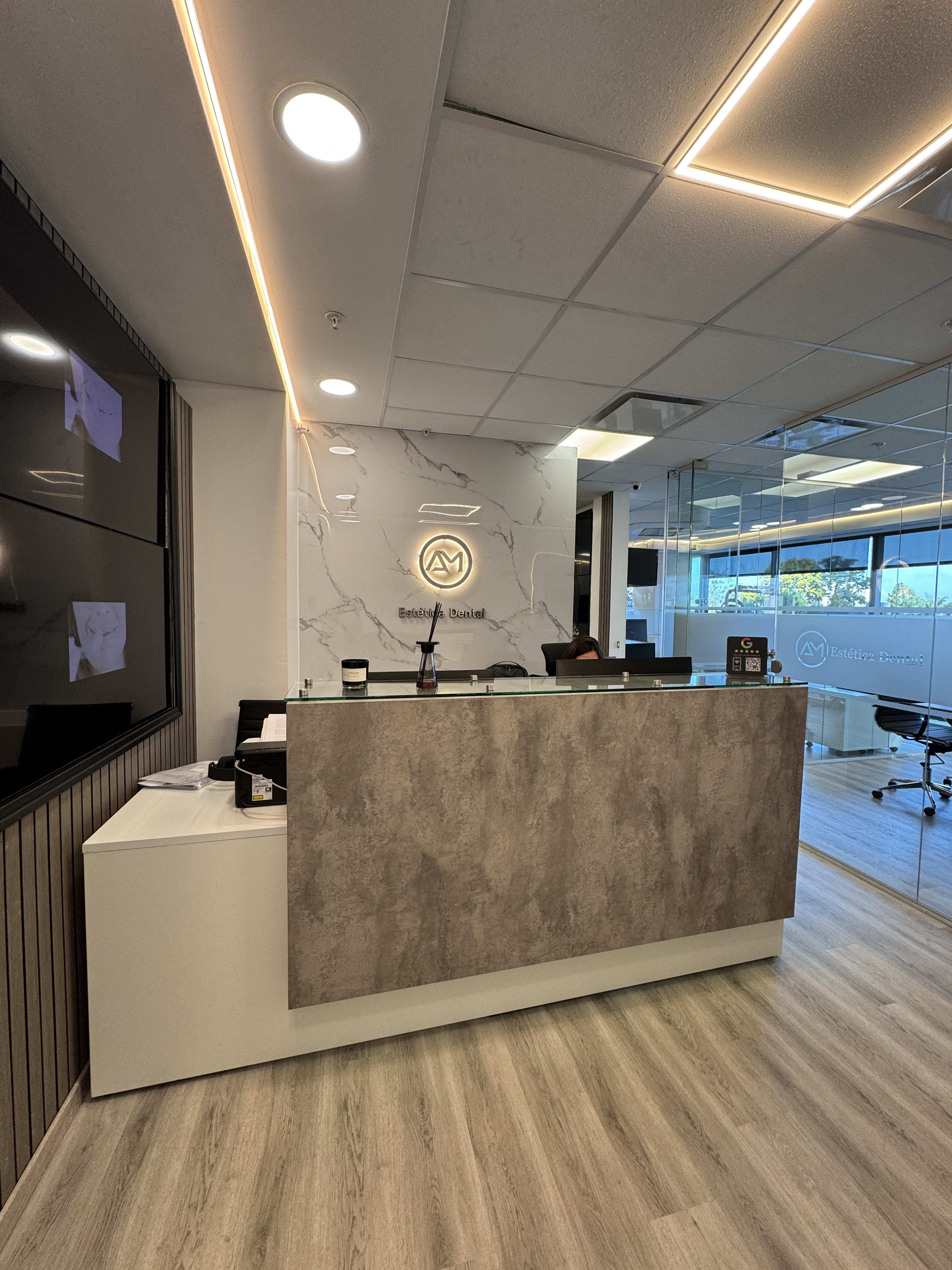 Recepción de AM Estética Dental con iluminación cálida en Puerto Madero, Buenos Aires