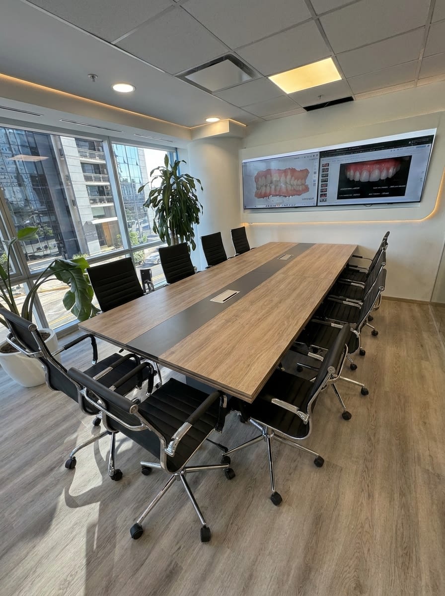 Sala de reuniones de AM Estética Dental en Puerto Madero con pantallas de diseño de sonrisa digital y ventanal al barrio