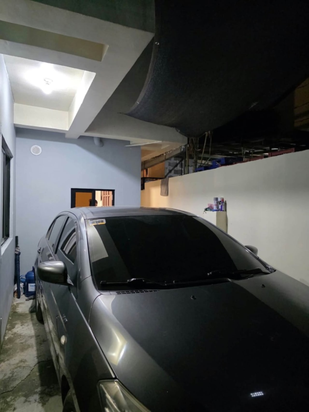 Black car in a garage in house and lot for sale in Tisa