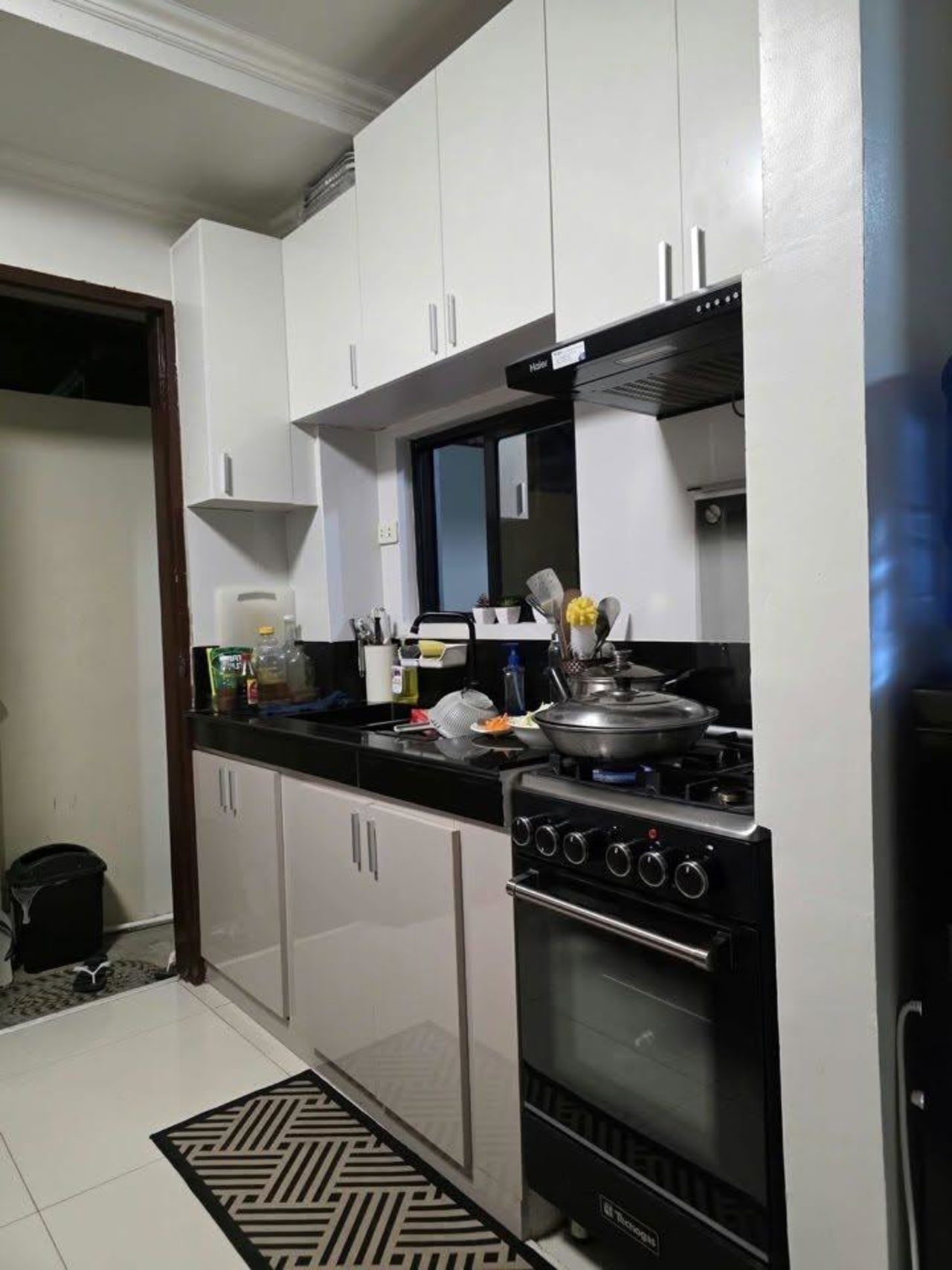 Kitchen with white cabinets and stove in house and lot for sale in Tisa