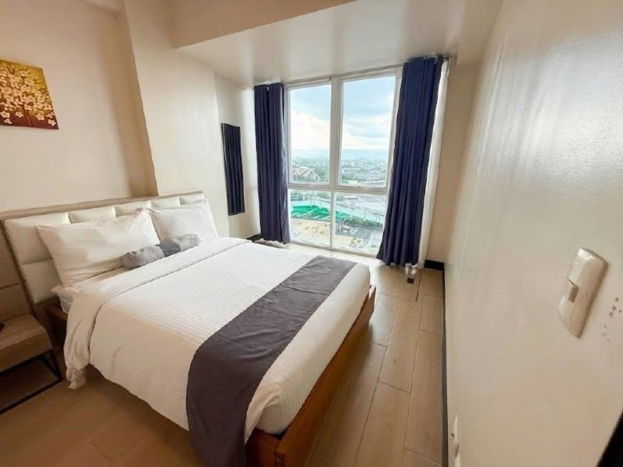 The Alcoves 1-bedroom condo bedroom with king-size bed and city view in Cebu City