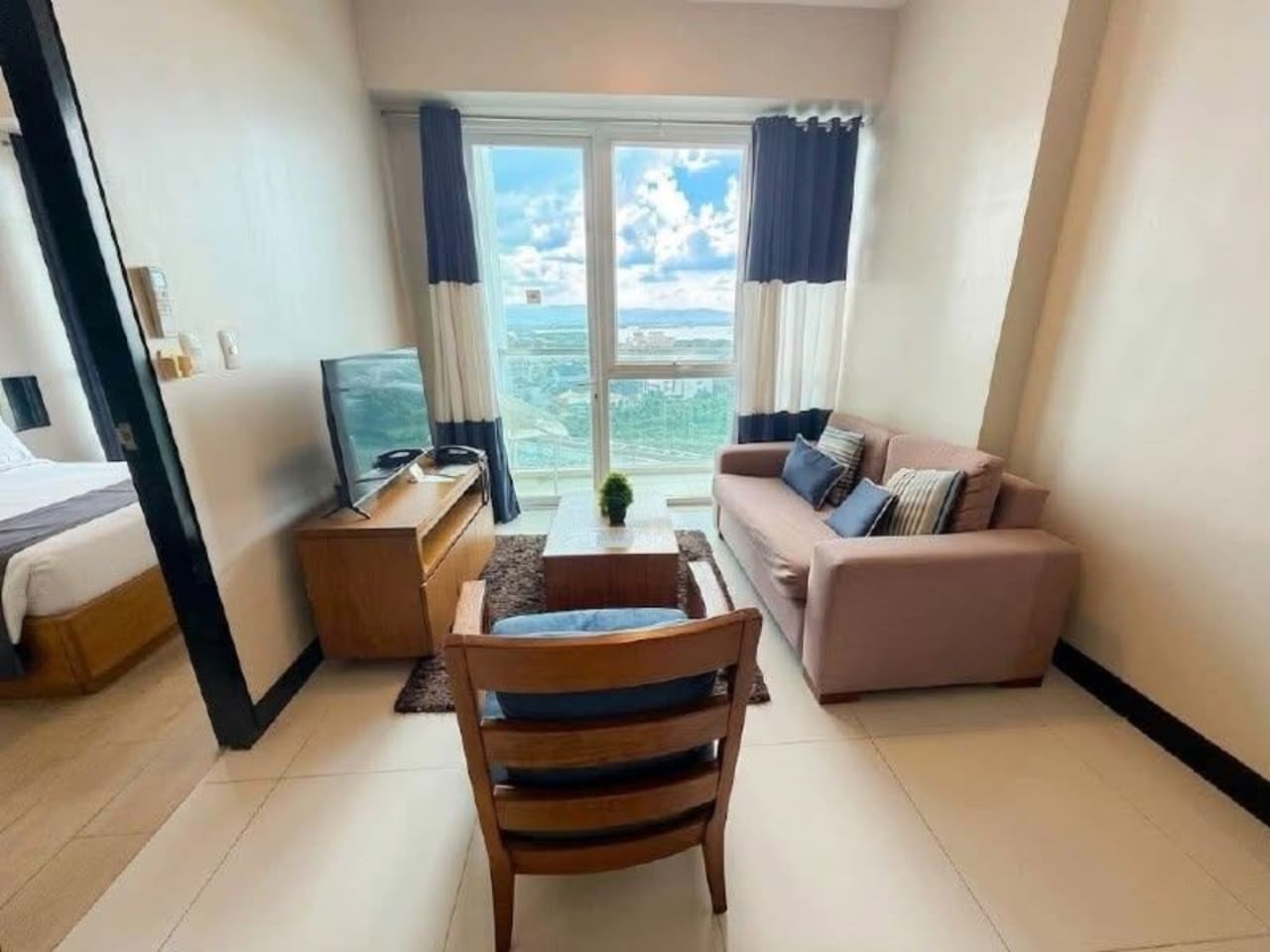 The Alcoves fully furnished 1-bedroom condo living room with sofa and city view