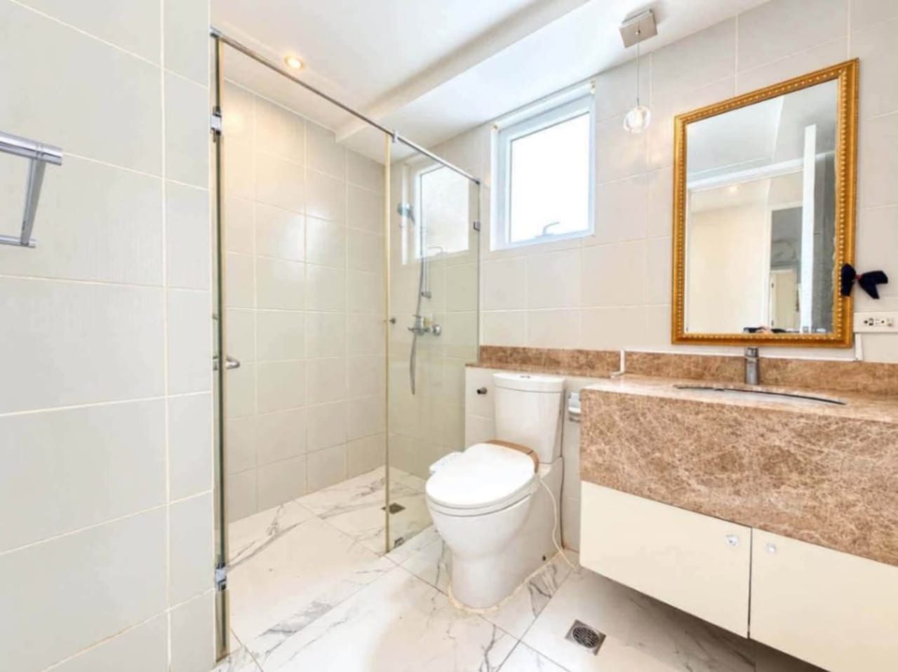 Second bathroom with frameless glass shower, wall-hung vanity and bidet toilet in Marco Polo Residences condo