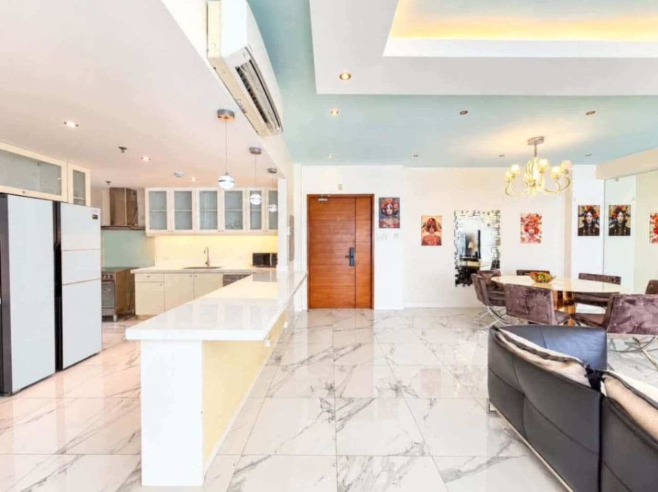 Condo entrance with wooden door, round marble dining table and mirrored wall at Marco Polo Residences