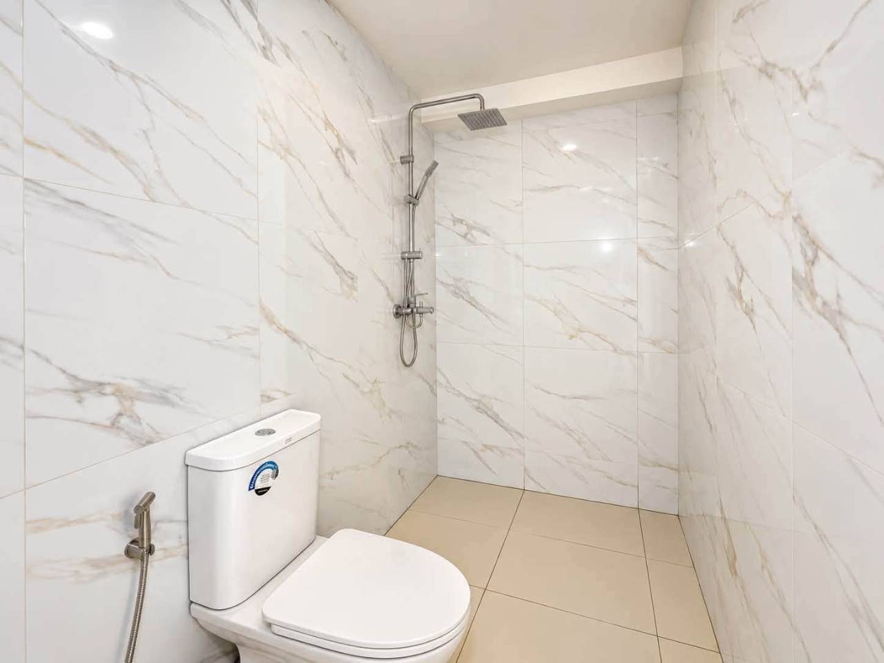 White marble-look tiled shower and toilet area in a 2-bedroom condo at Mandani Bay, Mandaue City