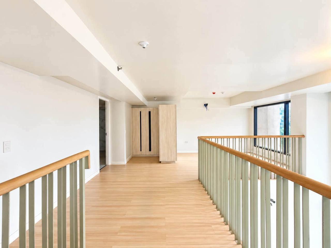 Wood-finish loft landing with metal railing in a 104 sqm 2-bedroom Mandani Bay condo