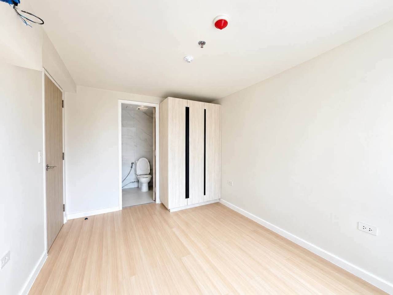 Unfurnished bedroom with built-in white wardrobe in a 2-bedroom loft condo at Mandani Bay Tower 2