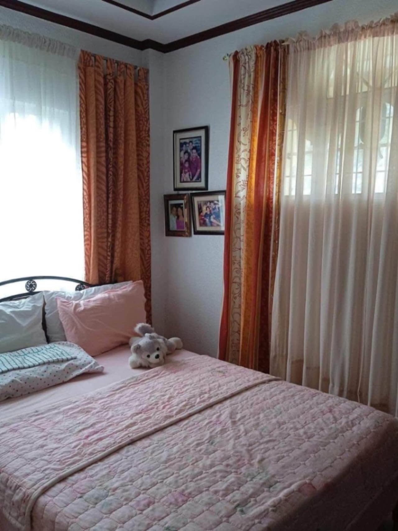 Bedroom with bed and window curtains in a 2-bedroom house for sale in Buagson, Cordova, Cebu.