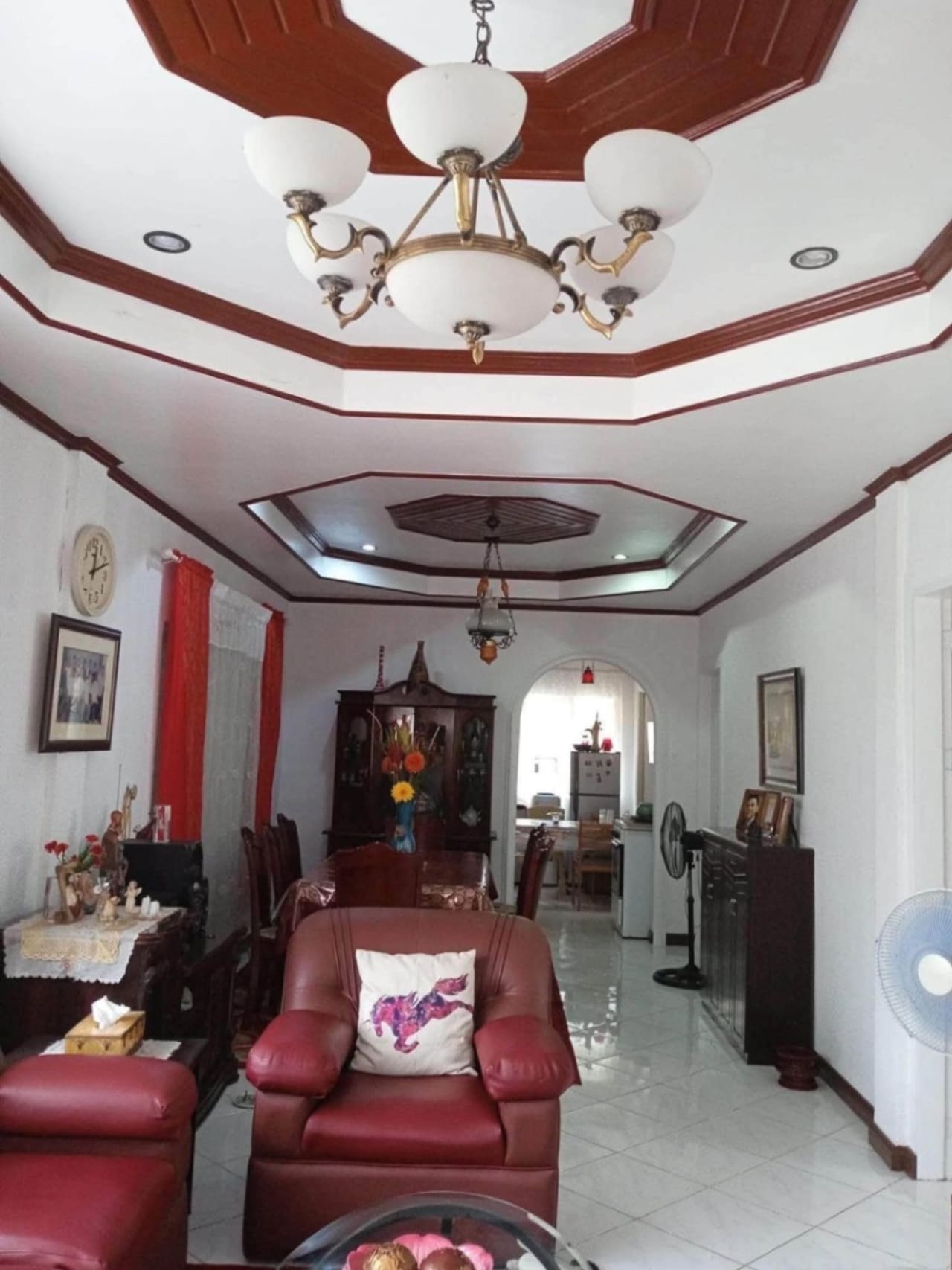 Living and dining area with leather seating and decorative ceiling lights in a house for sale in Cordova, Cebu.