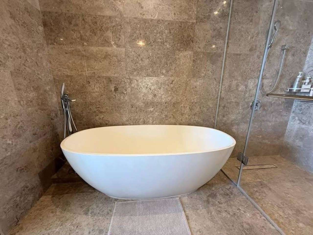 Freestanding bathtub in the modern bathroom of a luxury one-bedroom condo for sale at Sheraton Cebu Mactan Resort.