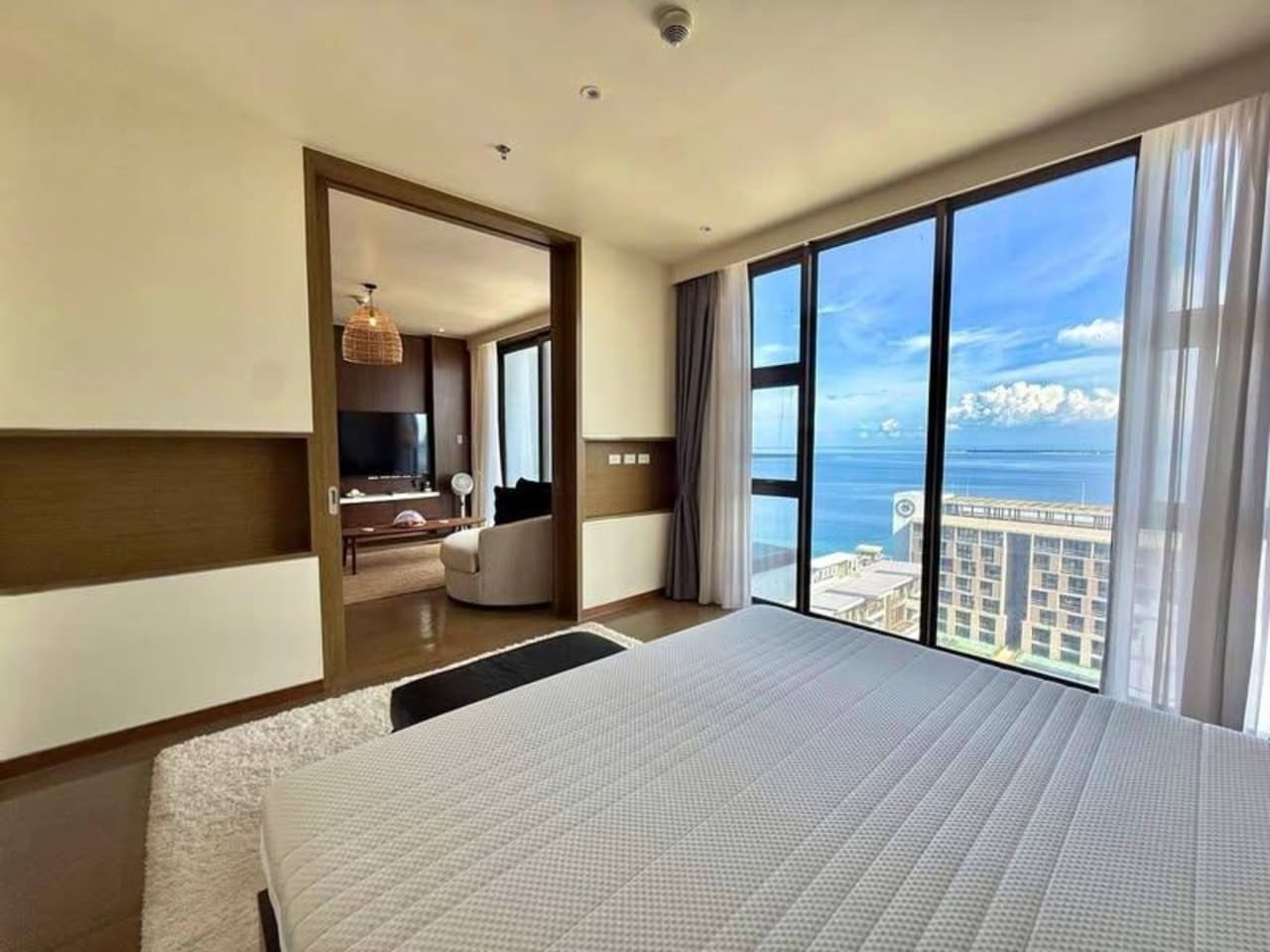 Bedroom with floor-to-ceiling windows and sea views in a 72 sqm luxury condo for sale at Sheraton Cebu Mactan Resort, Lapu-Lapu City.
