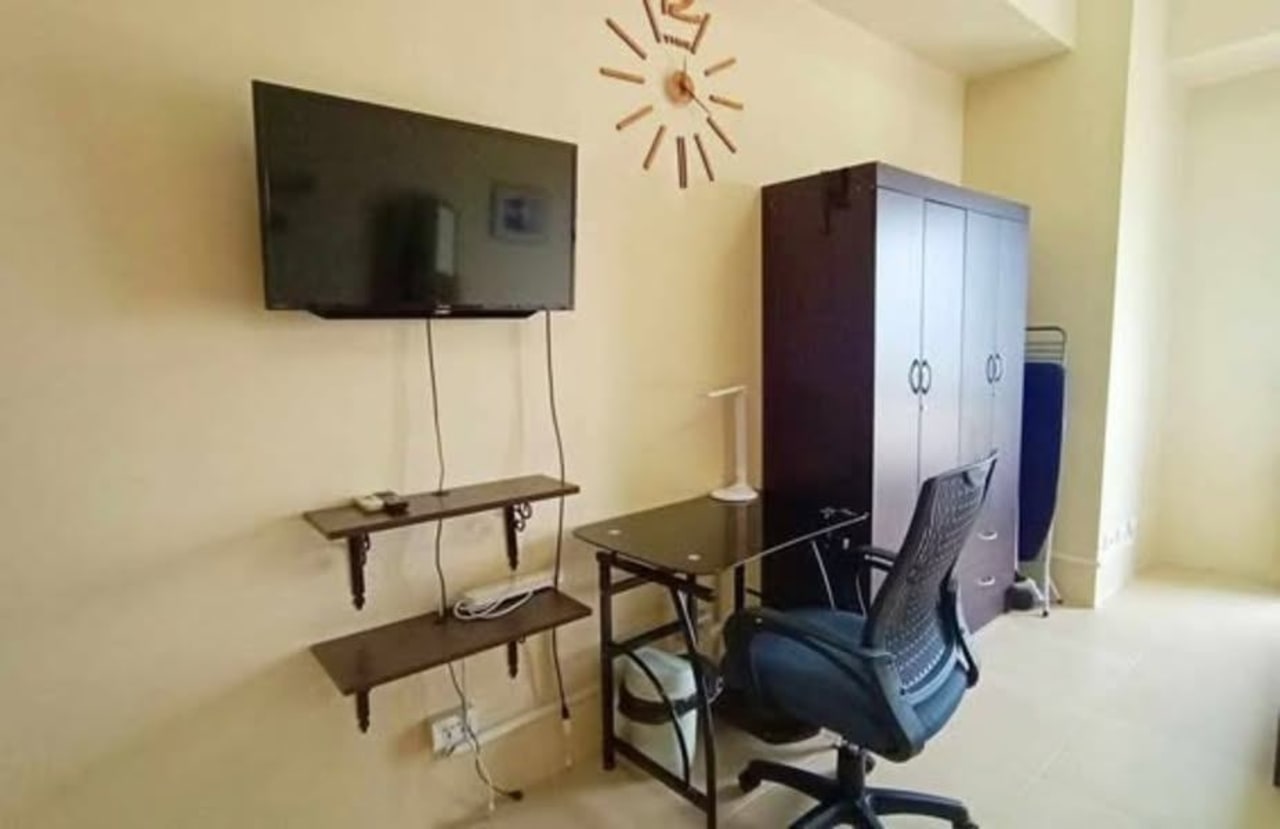 Wall-mounted television, floating shelves, and computer desk with office chair inside a fully furnished studio condo at Avida Riala Tower 3, Cebu IT Park.