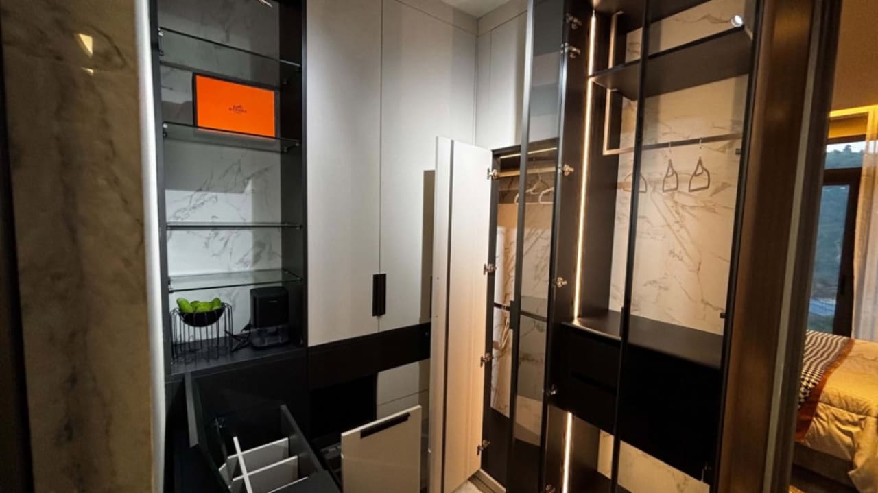 Built-in storage area with wooden shelving, dark cabinetry, and a compact laundry appliance in a modern house in Cebu City.