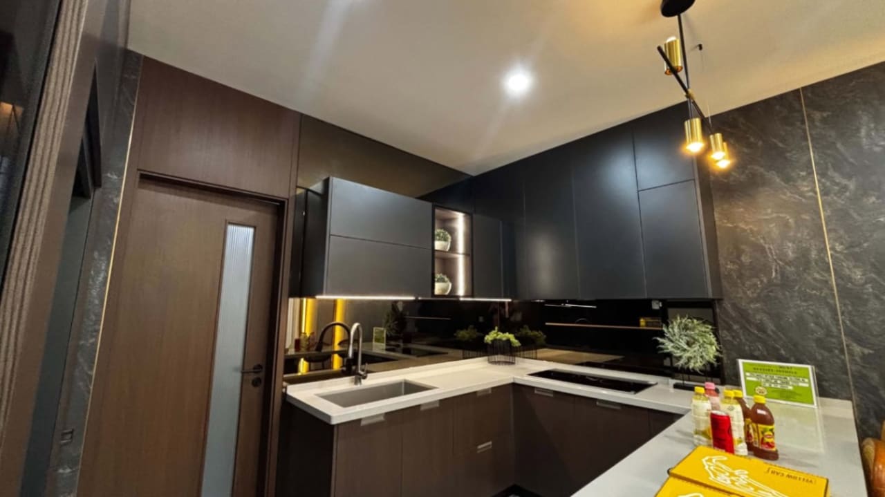 Modern kitchen with black countertops, built-in cabinetry, recessed ceiling lights, and yellow accent lighting in a 3-storey house for sale in Cebu City.