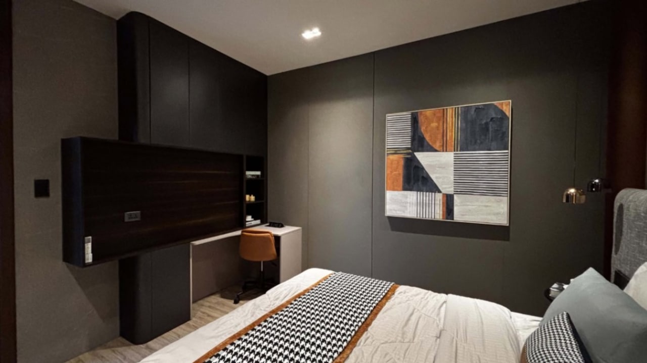 Bedroom with gray bedding, upholstered headboard, abstract wall art, bedside furniture, and dark accent walls in a contemporary Cebu City home.