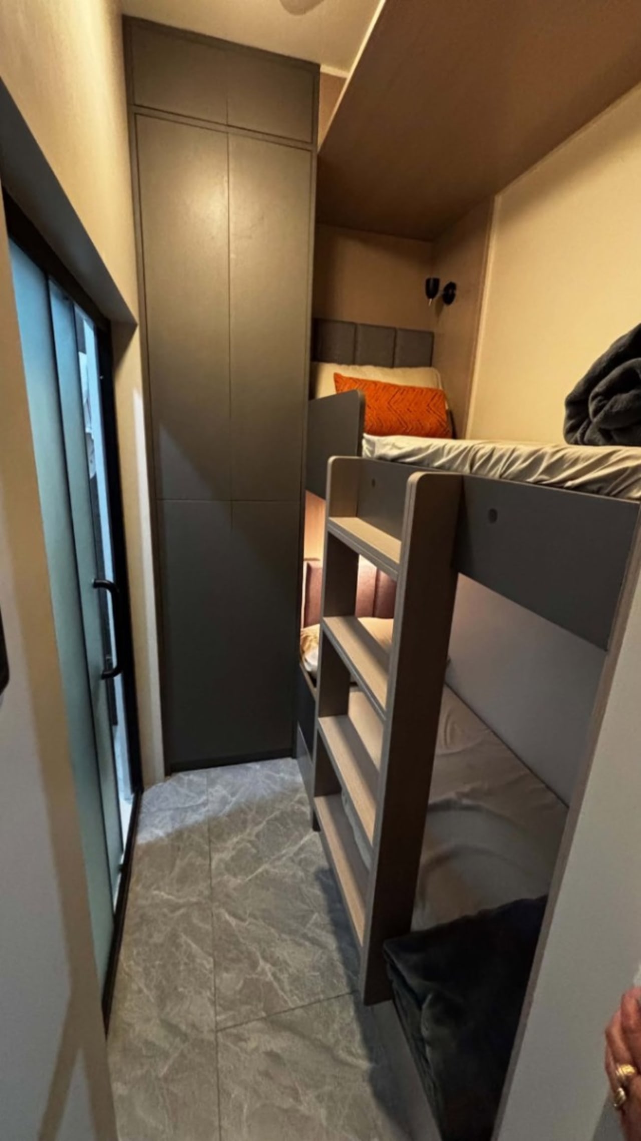 Compact bedroom with a bunk bed, built-in wardrobe, and gray patterned flooring in a modern house in Cebu City.