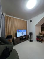Wide view of the living room with TV and black panels at the back in house and lot for sale in Tisa