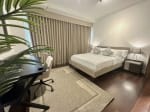 Fully furnished bedroom with king-size bed, work desk and curtains at The Alcoves Cebu condo