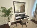 Home office desk and chair beside furnished bedroom in 1-bedroom condo for sale at The Alcoves Cebu