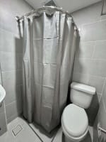 Bathroom with tiled walls, shower enclosure and toilet in fully furnished JTower Residences studio Mandaue