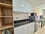 Modern kitchen with white cabinets, range hood, refrigerator and microwave in JTower Residences studio Mandaue