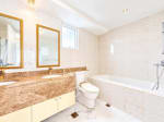 Bathroom with double vanity, gold-framed mirrors, marble countertop and bathtub in Marco Polo Residences condo, Cebu City