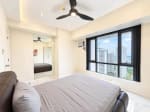 Bedroom with leather bed, ceiling fan and high-floor window view of Cebu City towers at Marco Polo Residences