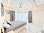Corner master bedroom with sheer curtains and panoramic city and sea views at Marco Polo Residences, Cebu City
