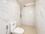 White marble-look tiled shower and toilet area in a 2-bedroom condo at Mandani Bay, Mandaue City