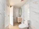 Bright bathroom interior with vanity, toilet and tiled walls in a Mandani Bay Tower 2 condo for sale