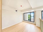 Bright upper-level loft room with wood flooring and large windows in a Mandani Bay Tower 2 condo