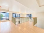 Spacious open loft interior with wood flooring and mezzanine railing in a 104 sqm condo for sale in Mandaue City
