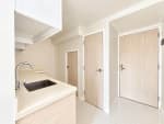 Compact modern kitchen with white cabinets and countertop in a Mandani Bay Tower 2 loft condo