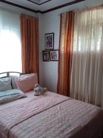 Bedroom with bed and window curtains in a 2-bedroom house for sale in Buagson, Cordova, Cebu.